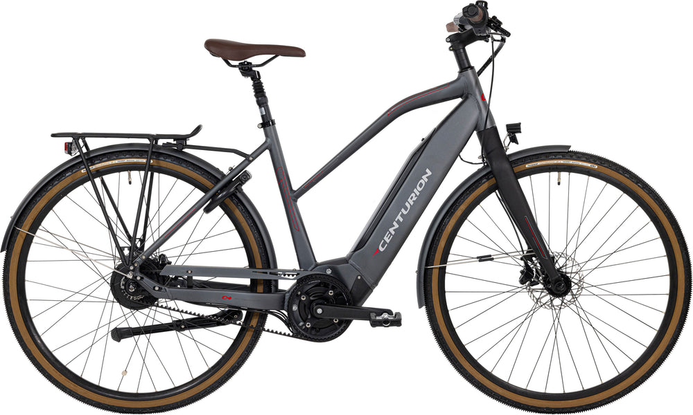 Centurion Invincible E Dame Belt: En elegant elcykel til kvinder, der står på en cykelsti med grønne træer i baggrunden.