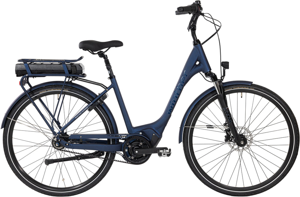 Winther Superbe 3 LTD i mat mørkeblå, elcykel med kurv og bagagebærer, set fra siden i bymiljø.